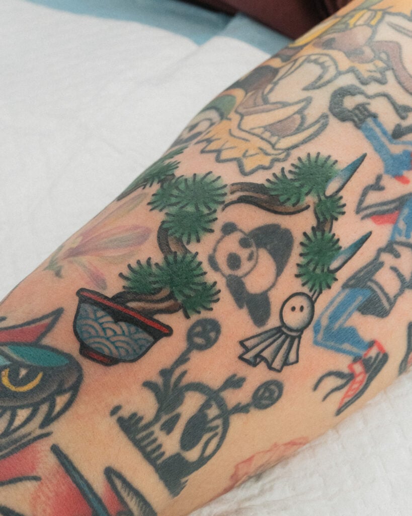 Color bonsai tattoo with green foliage and patterned pot, created at Good Times Ink Osaka.
