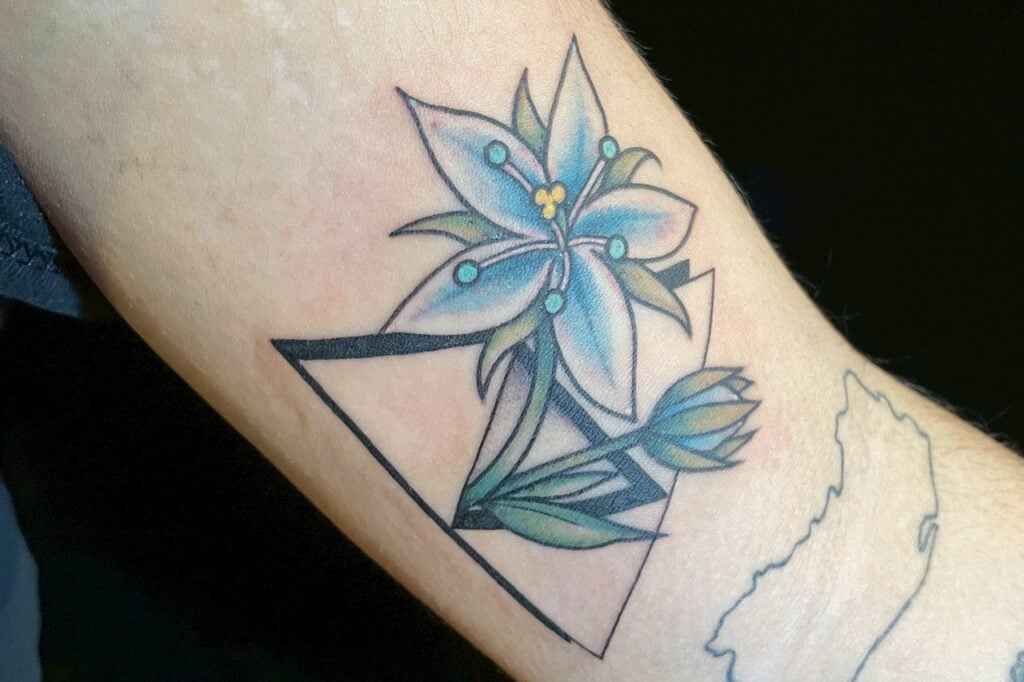 Zelda-inspired tattoo combining a Triforce shape with a stylized lily flower, created at Good Times Ink Osaka.