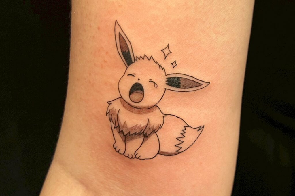 Black and grey Eevee tattoo with simple linework and soft shading, created at Good Times Ink Osaka.