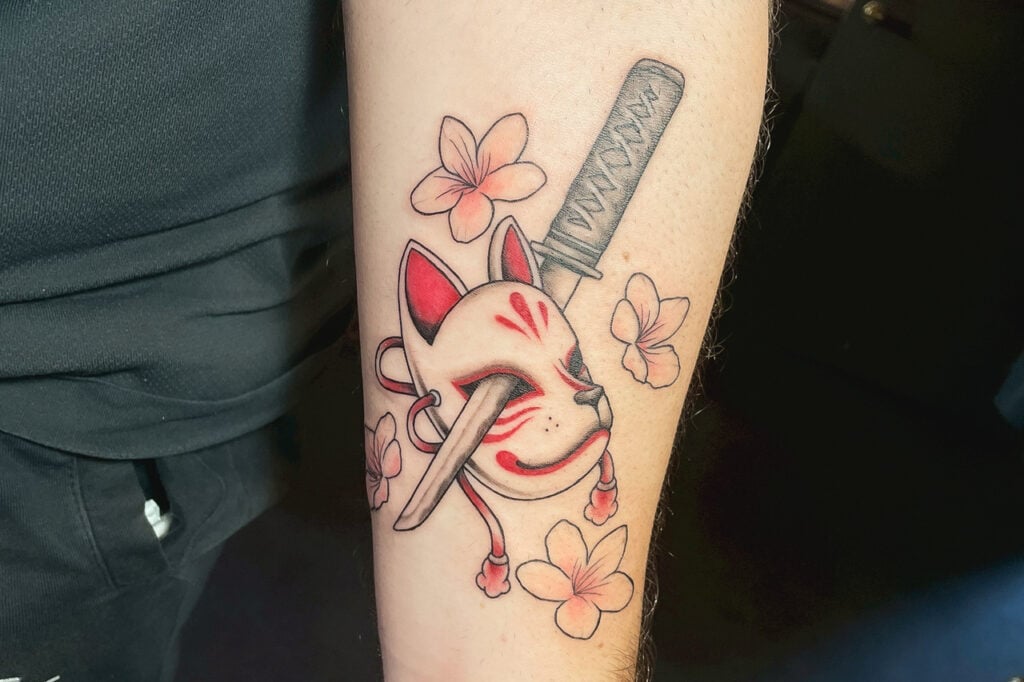 Small red-and-white kitsune mask tattoo, created at Good Times Ink Osaka.
