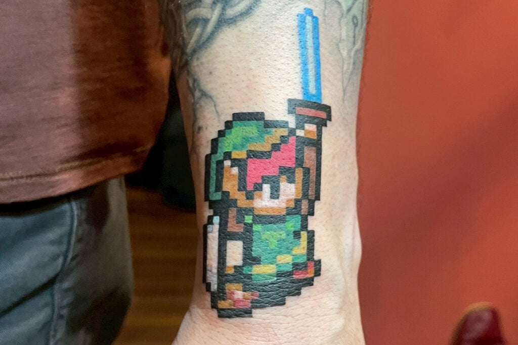 Pixel-art Link tattoo in retro 8-bit style, created at Good Times Ink Osaka.