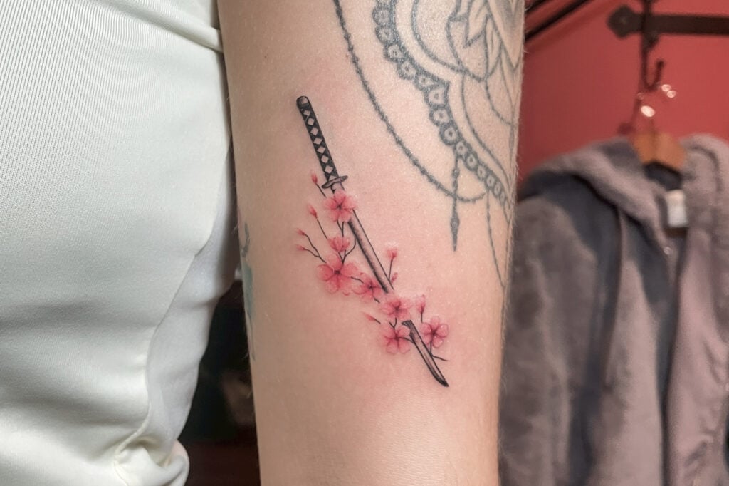 Katana tattoo with red circle and kanji lettering, created at Good Times Ink Osaka.