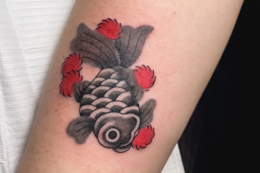 Goldfish tattoo with red accents and bold shading, created at Good Times Ink Osaka.