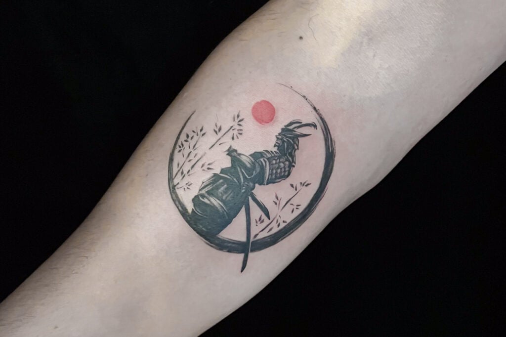Brush-stroke enso tattoo with samurai silhouette inside the circle, created at Good Times Ink Osaka.