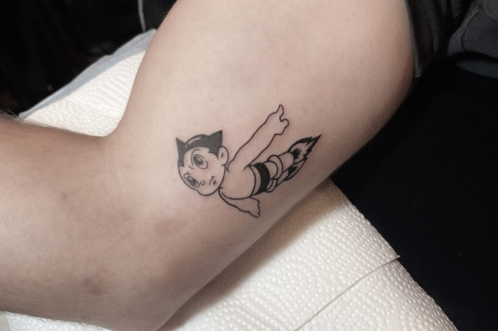 Astro Boy streamlined motif tattoo with clear rocket curves.