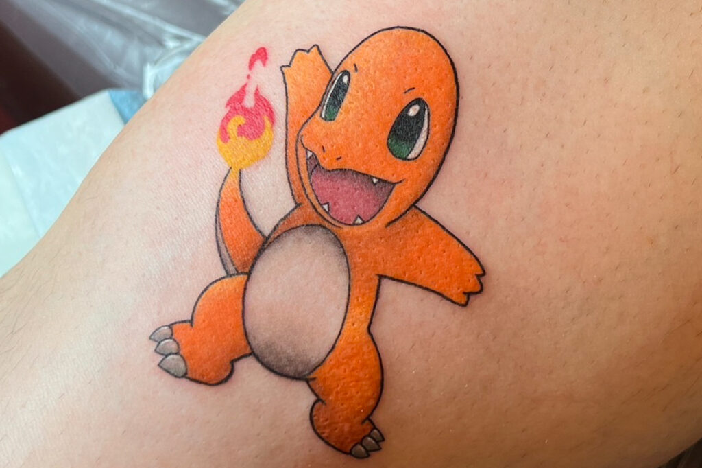 Classic color Charmander tattoo with bright shading and a glowing tail flame, created at Good Times Ink Osaka.