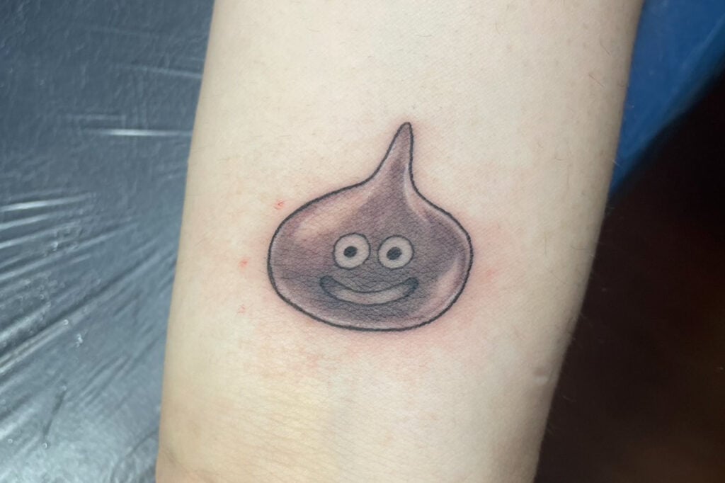 Black and grey Metal Slime tattoo with soft metallic shading, created at Good Times Ink Osaka.
