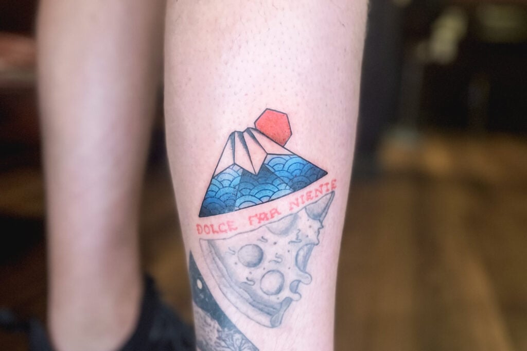 Colorful Mount Fuji tattoo with blue waves and red sun, created at Good Times Ink Osaka.