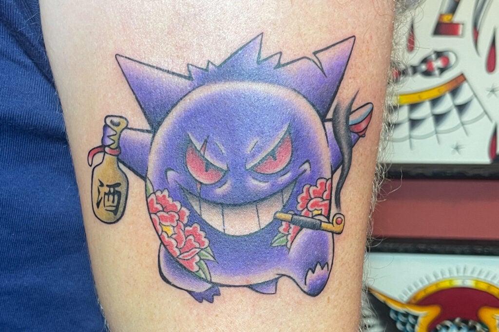 Japanese-inspired Gengar tattoo with double-tattoo details, sake bottle, and kiseru pipe, created at Good Times Ink Osaka.