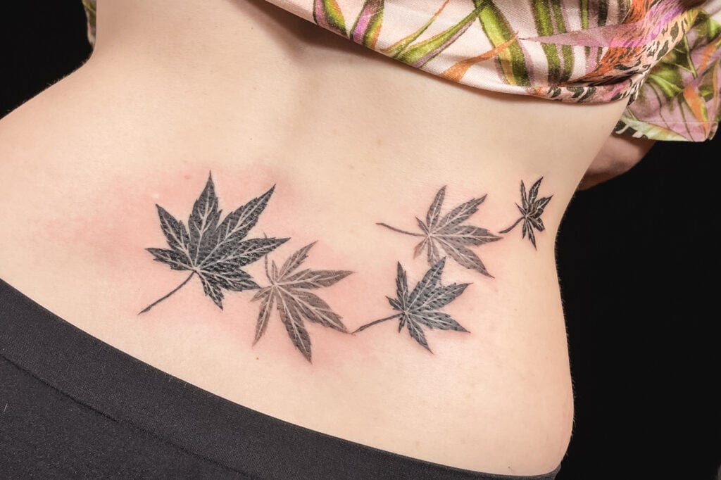 Black-and-gray maple leaf tattoo arranged in a flowing pattern, created at Good Times Ink Osaka.