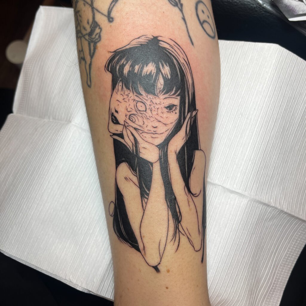 Tomie blackwork tattoo with flowing hair and controlled mood.