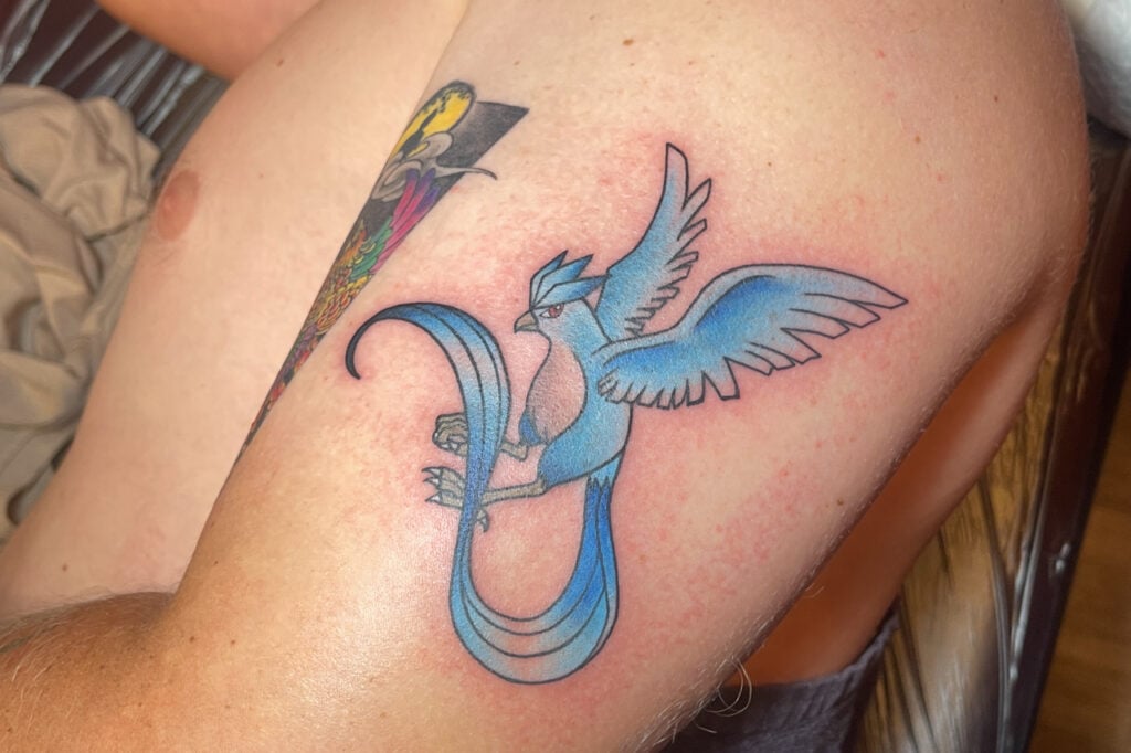Articuno tattoo with classic blue coloring and elegant flowing tail, created at Good Times Ink Osaka.