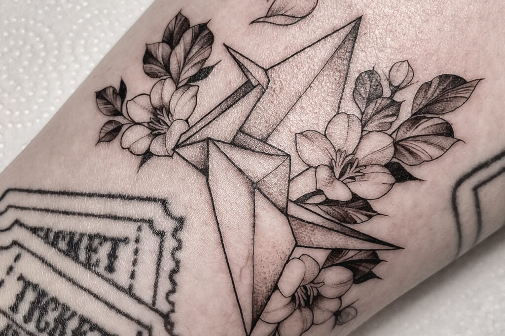 Origami crane tattoo with sakura flowers and leaves, created at Good Times Ink Osaka.