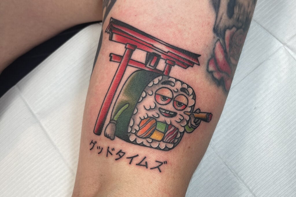 Cartoon sushi character tattoo paired with a red torii gate, created at Good Times Ink Osaka.