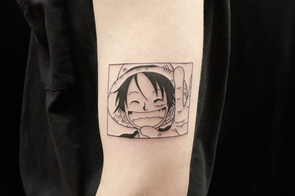 Luffy wanted‑poster style tattoo clearly showing straw‑hat hero.