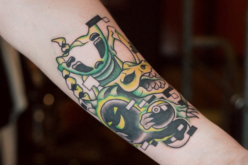 Glitch-inspired Bug Pokémon tattoo with distorted shapes and error-style design, created at Good Times Ink Osaka.