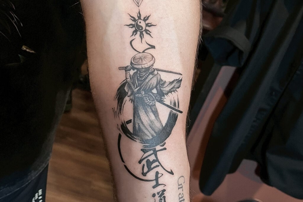 Samurai tattoo with brush-stroke ink elements, created at Good Times Ink Osaka.