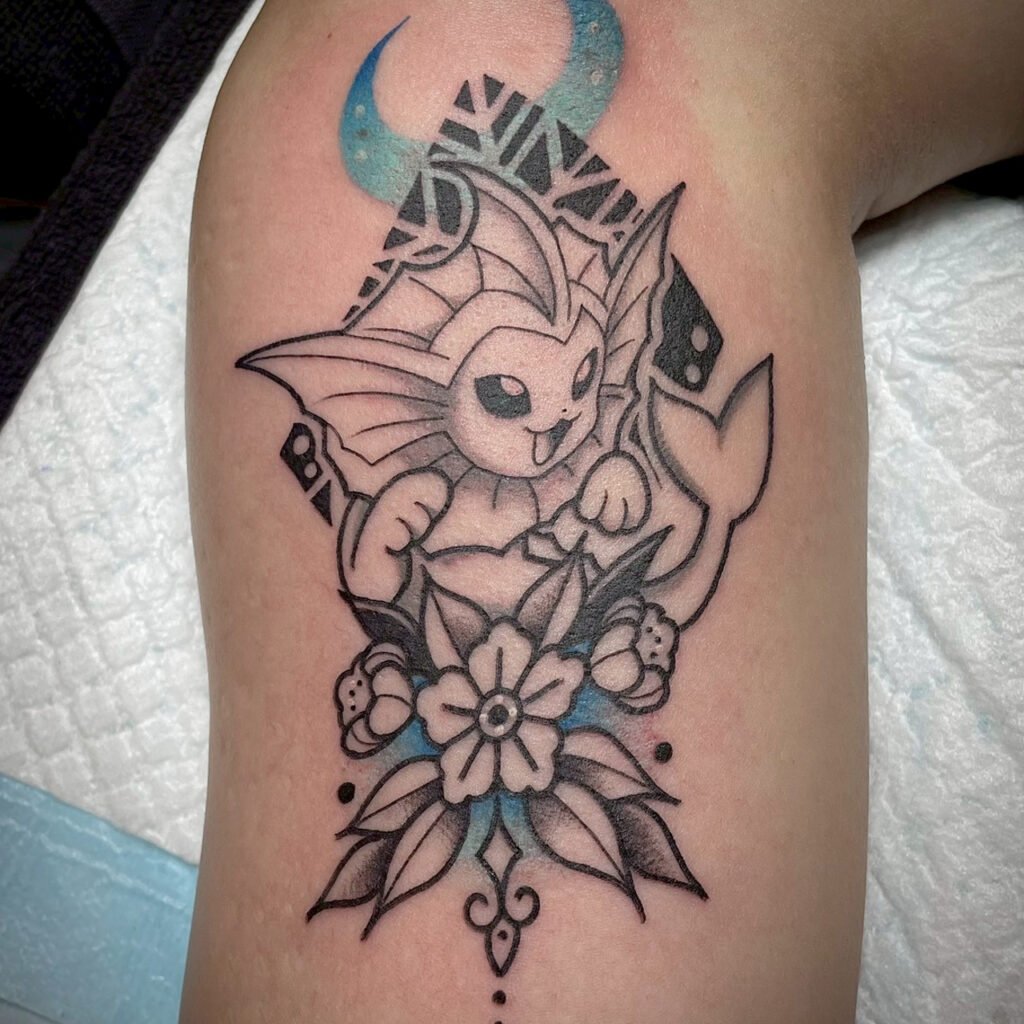 Geometric Vaporeon tattoo with black and grey shading and an American Traditional flower, created at Good Times Ink Osaka.