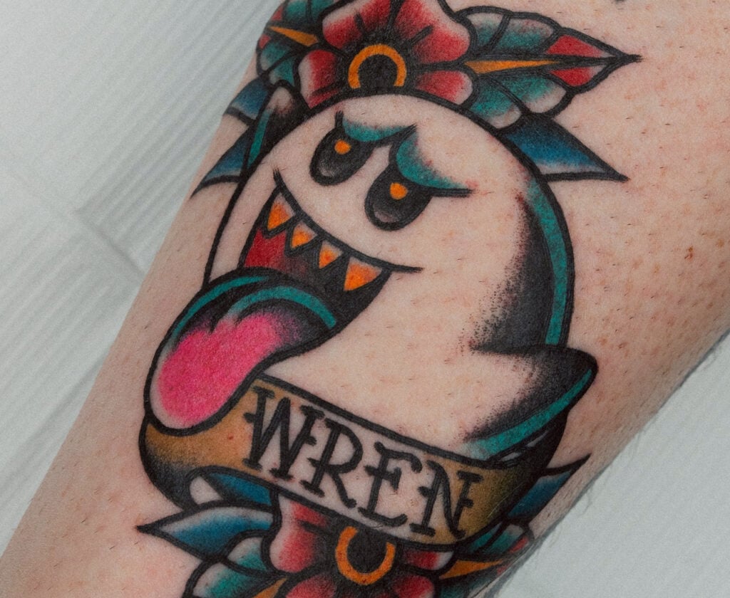 Trad / New School–style Boo tattoo with teal accents and lettering, created at Good Times Ink Osaka.
