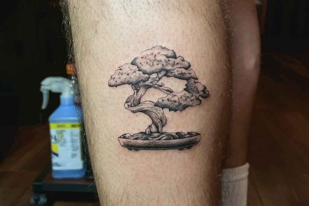 Black-and-gray bonsai tattoo with detailed trunk and foliage, created at Good Times Ink Osaka.
