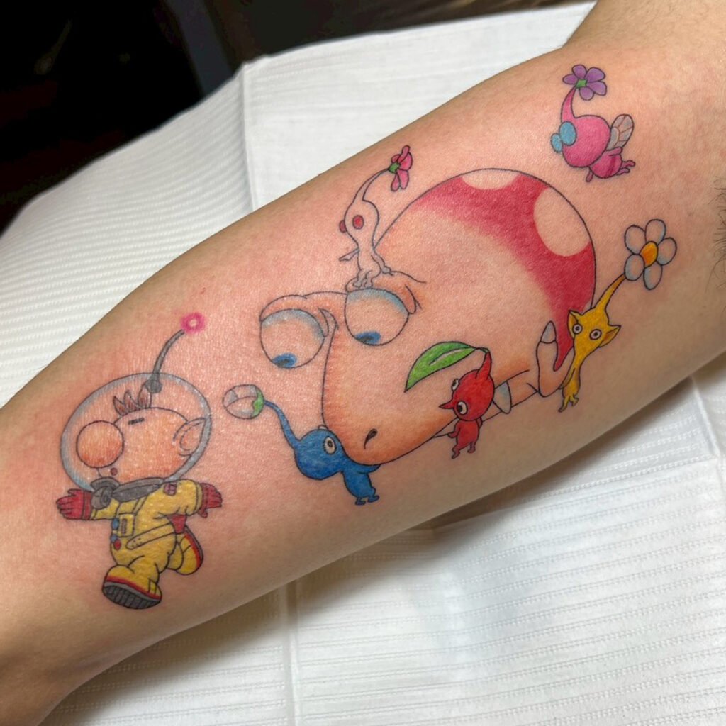 Olimar and Pikmin chase-scene tattoo with bright primary colors, created at Good Times Ink Osaka.